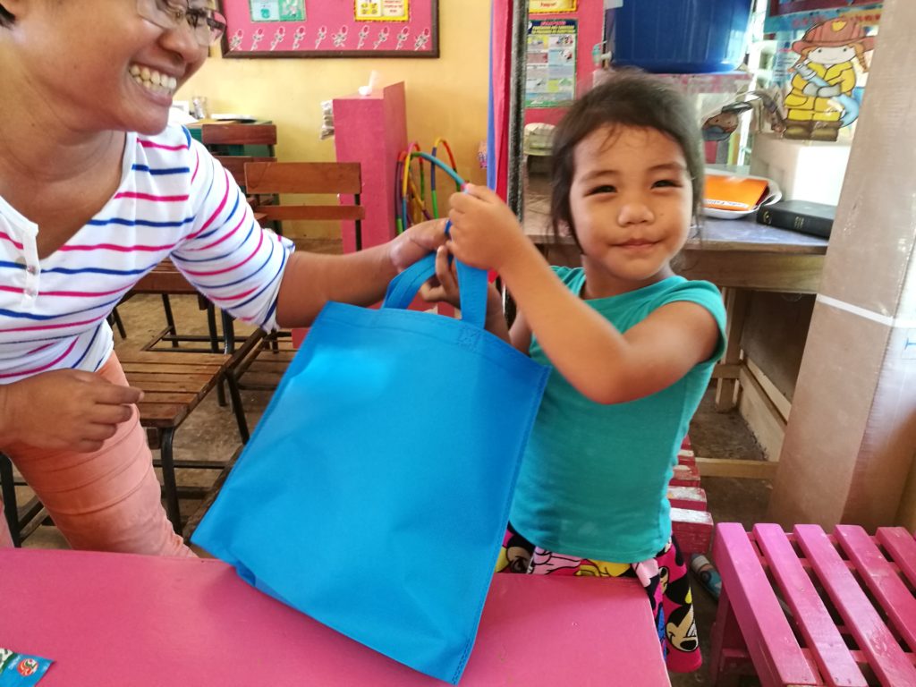 kid in bayobay elementary school given a bag full of school supplies
